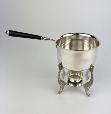 a silver pot with a black handle on a saucer