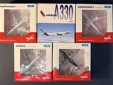 quatre maquettes d'avions posées les unes à côté des autres sur une table