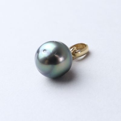 a black pearl on a gold ring on a white surface