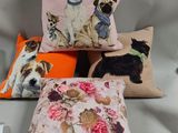 three pillows with dogs on them sitting on a chair