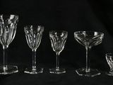 six verres à vin sont alignés sur un fond noir