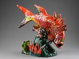 a figurine of a fish that is sitting on top of a plant