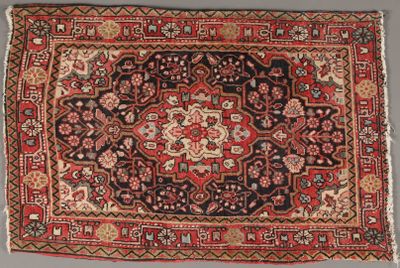 un tapis persan ancien aux couleurs rouge et noir