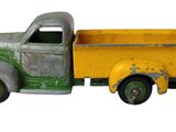 un camion jouet vert et jaune sur fond blanc