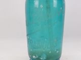 a blue glass bottle with a metal stopper on it