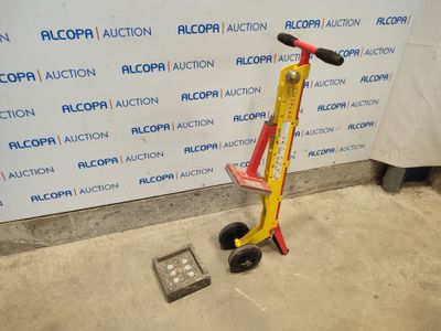a red and yellow scooter sitting next to a wall