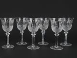 a set of six crystal wine glasses on a black background