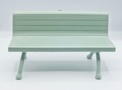 a green bench that is sitting on a white surface