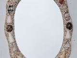 a mirror that has shells on it in the shape of a circle