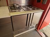 une cuisine équipée d'une cuisinière, d'un évier et d'un réfrigérateur
