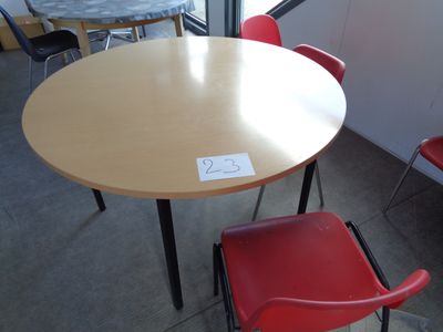 a table and chairs in a room with a sign on the table