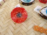 a red flower sitting on top of a table next to other items