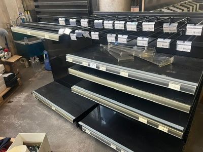 a lot of empty shelves in a store with labels on them