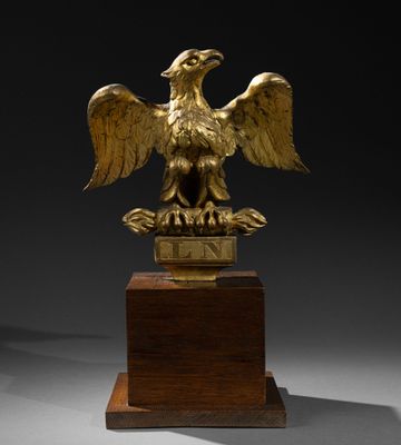 une image représentant une statue d'aigle royal posée sur un socle en bois