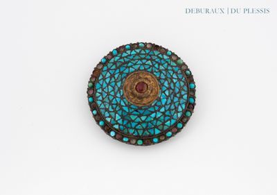un gros plan sur une broche présentant un motif bleu et marron