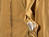the back of a tan jacket with a label on it