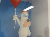 a white bear holding a red balloon in a white box