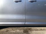 a silver car parked in a parking lot with its door open