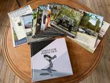 plusieurs livres posés sur une table, sur laquelle se trouvent des magazines