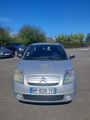 a silver car parked in a parking lot with other cars in the background