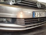 a silver car parked in a garage with a number plate on the front