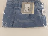 Le pantalon bleu est emballé dans du plastique et prêt à être porté.