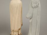 two figurines of a man and a woman standing next to each other