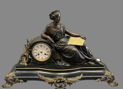 a statue of a woman sitting on top of a clock