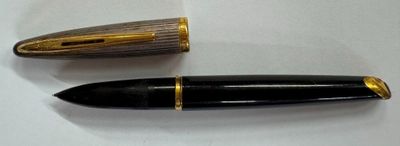 two pens sitting on a white surface next to each other