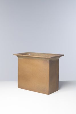 l'image d'un vase brun posé sur une table blanche