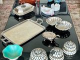 a black table with a tray of silver and glass items on it