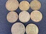 six pièces de monnaie britanniques différentes sont disposées en rangée sur un tissu bleu