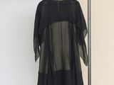 the black dress is hanging on a hanger in a room