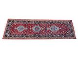 a red and black rug with a diamond design on it