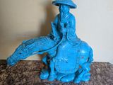 une statue représentant un homme chevauchant un éléphant bleu