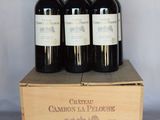 three bottles of wine are in a wooden box on a table