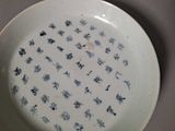 a white plate with blue flowers on it sitting on a table