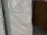 deux matelas emballés dans du plastique dans une pièce