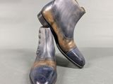 pair of men ' s blue and brown leather boots on a gray surface