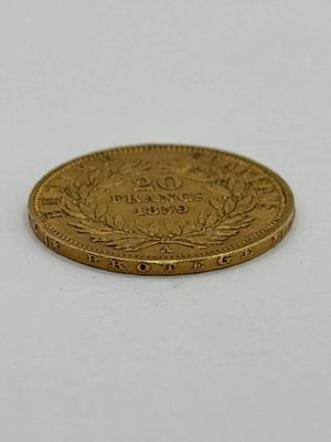 gros plan d'une pièce d'or sur une surface blanche