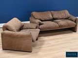 a couch and a chair in a room with a blue wall