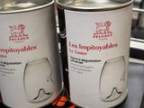 two tins of wine sitting on a shelf