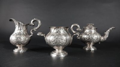 trois théières en métal argenté et une cafetière sur fond noir