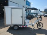 a bike with a trailer attached to it parked in front of a building