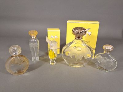 trois flacons de parfum et une boîte de parfum posés sur une table