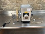 un plan de travail en acier inoxydable avec un mixeur, un couteau et d'autres ustensiles de cuisine