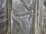 de nombreux meubles emballés dans du plastique dans un entrepôt
