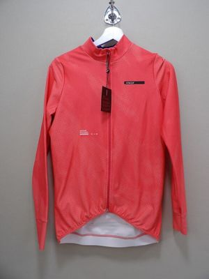 une veste rose suspendue à un cintre accroché au mur