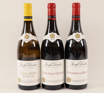 trois bouteilles de vin sont alignées sur une surface blanche