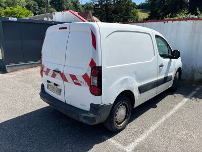 a white van parked in a parking lot with a surfboard on the roof